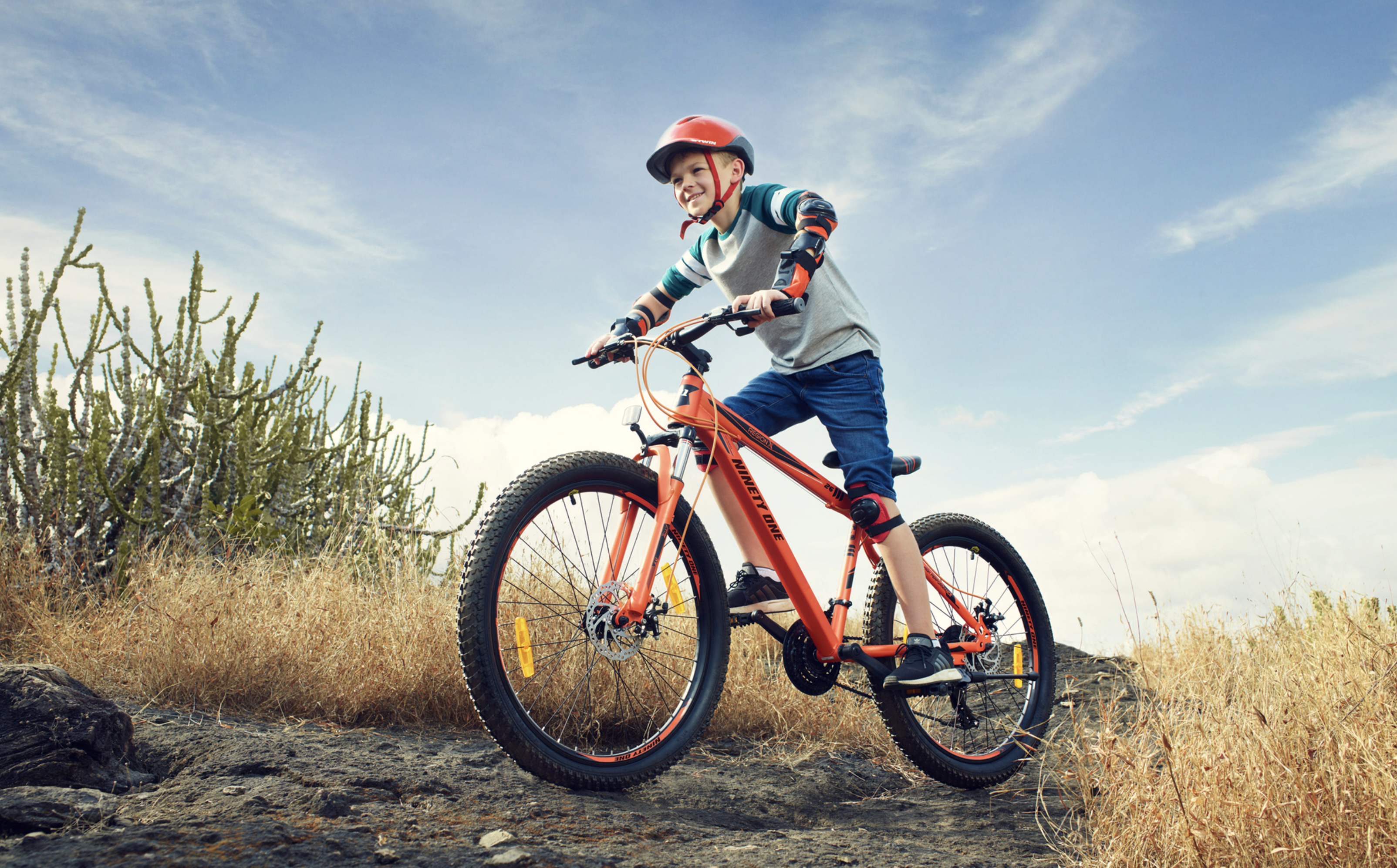 Child riding an orange bicycle